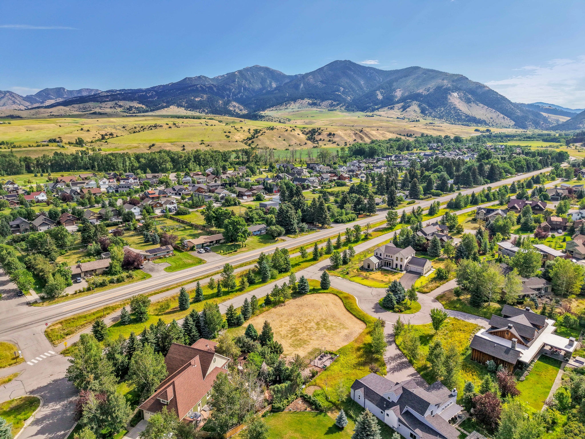 Suburban area with many trees and greenery shown from an aerial view with Bridger Mountain views in Bozeman, Montana