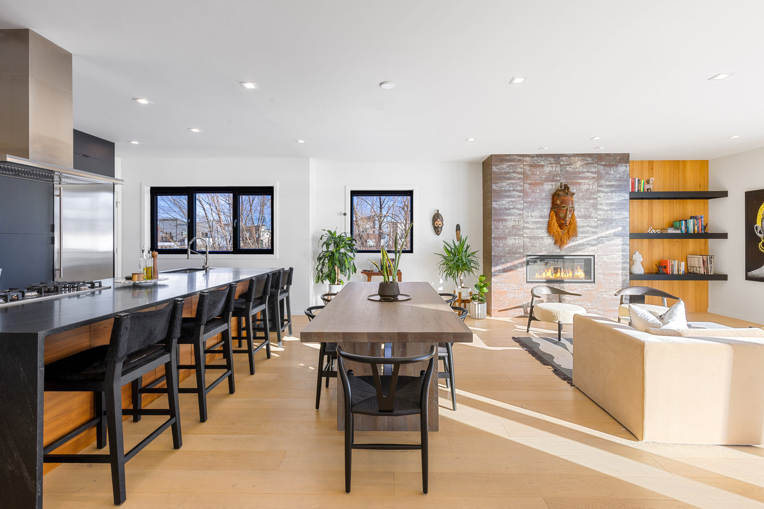 Bright living room kitchen and dining area with indoor plants and fireplace in Bozeman, Montana