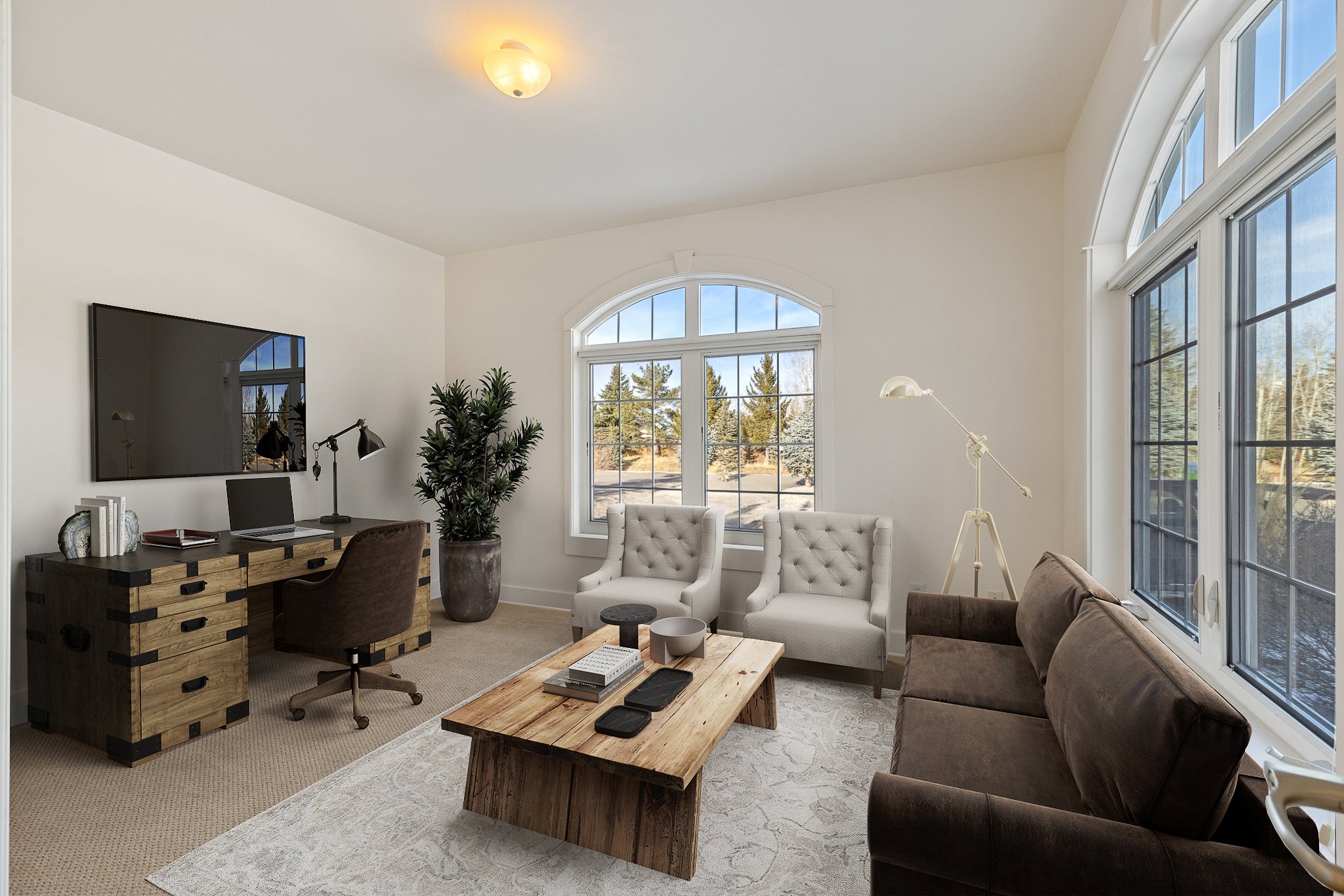 White room with tan carpet and virtually-staged sitting room complete with office furniture and TV in Bozeman, Montana